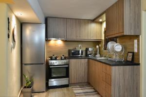 eine Küche mit Holzschränken und einem Edelstahlkühlschrank in der Unterkunft George & Helen's House in Ayiá