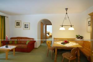 a living room with a couch and a table at Landhaus Alpensonne in Schattwald