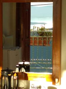 een keukenraam met uitzicht op een balkon bij Sun View Guesthouse in Delfoi