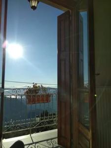 een deur naar een kamer met uitzicht op een balkon bij Sun View Guesthouse in Delfoi