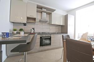 a kitchen with white cabinets and a table and chairs at BELLAGIO DREAMS APT, pool, with private garden, near lake in Bellagio +38 photos