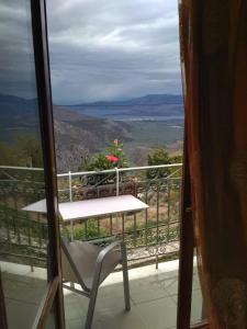 een tafel en een stoel op een balkon met uitzicht bij Sun View Guesthouse in Delfoi