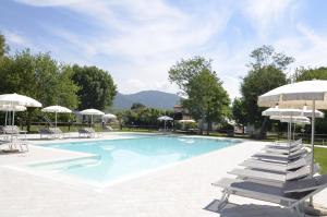 a swimming pool with lounge chairs and umbrellas at Agriturismo La Pisana in Pisa