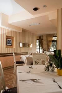 a dining room with white tables and chairs at Pensiunea Diamant in Ghimbav