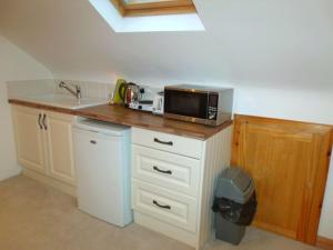 een keuken met een magnetron op een aanrecht bij tranquil apartment near Kenmare in Lomanagh