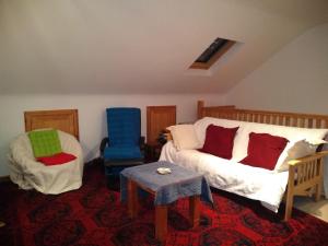 ein Wohnzimmer mit einem Sofa und 2 Stühlen in der Unterkunft tranquil apartment near Kenmare in Lomanagh