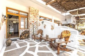 a patio with two chairs and a stone wall at Limeri Traditional Guest House in Monólithos