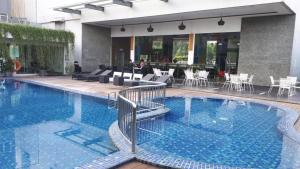 una piscina en un hotel con mesas y sillas en ibis Styles Cikarang, en Cikarang