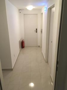 ウィーンにあるCHホステルの白いドアと赤いスーツケースを持つ廊下