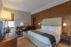 a hotel room with a large bed and a desk at The Manor - New Delhi in New Delhi