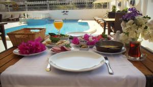 a table with plates of food and a glass of wine at Carikci Hotel in Marmaris