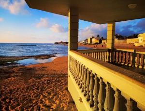 - une vue sur la plage depuis le balcon d'une maison dans l'établissement La stella di Montalbano con parcheggio privato, à Punta Secca