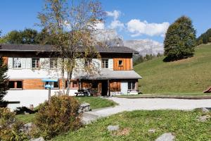 uma casa numa colina com montanhas ao fundo em Village Vacances Le Salvagny em Sixt