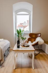 een kamer met een tafel, een stoel en een raam bij Szczecin Old Town Apartments - Riverside Lux Studio in Szczecin