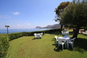 a group of white tables and chairs on the grass at Casa Hermosa in Cefalù