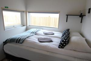 a bed in a room with two windows at Blue View Cabin 7A With private hot tub in Reykholt