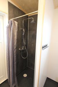 a bathroom with a shower with a shower curtain at Blue View Cabin 7A With private hot tub in Reykholt