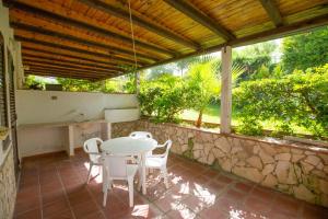 una mesa y sillas en un patio con una pared de piedra en Casa Hermosa, en Cefalú