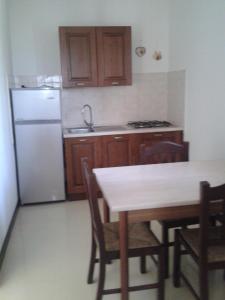 a kitchen with a table and a white refrigerator at Tenuta La Spezia in Carpignano Salentino