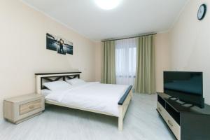 a bedroom with a bed and a flat screen tv at Видовая квартира Yaroslavichi-2 in Vyshhorod