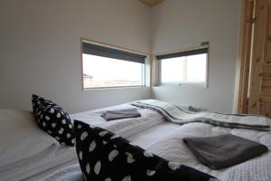1 Schlafzimmer mit 2 Betten und 2 Fenstern in der Unterkunft Blue View Cabin 7B With private hot tub in Selfoss