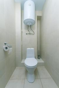 a bathroom with a toilet with a light above it at Видовая квартира Yaroslavichi-2 in Vyshhorod