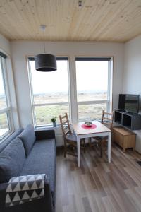 ein Wohnzimmer mit einem Sofa und einem Tisch in der Unterkunft Blue View Cabin 7B With private hot tub in Selfoss