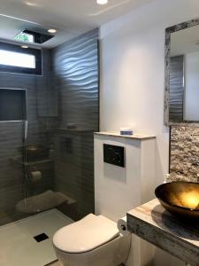 y baño con aseo, lavabo y ducha. en Luxury apartment in La Isla, walking distance to Puerto Banus en Marbella