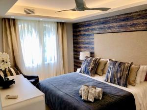 1 dormitorio con cama azul y pared de madera en Luxury apartment in La Isla, walking distance to Puerto Banus en Marbella