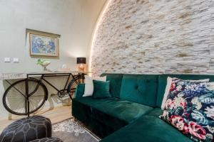 - un canapé vert dans le salon doté d'un mur en briques dans l'établissement Old Town Square Apartments by Michal&Friends, à Prague