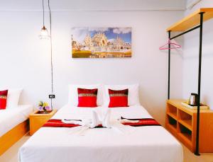 sypialnia z 2 łóżkami i czerwonymi poduszkami w obiekcie Little Lanna Guesthouse w mieście Chiang Mai