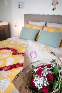 Una cama con un ramo de flores. en Les Fines Bulles & spa, en Bourseville