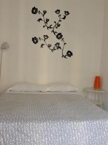 1 dormitorio con 1 cama con flores negras en la pared en Loft Regio Parco, en Turín