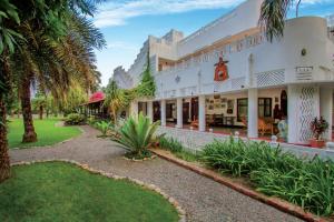an exterior view of a resort with palm trees at Jaagir Manor, Dudhwa - IHCL SeleQtions in Paliā Kalān +37 photos