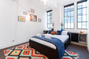 a bedroom with a large bed and a rug at Spacious Designer Warehouse Melbourne CBD Apartment in Melbourne