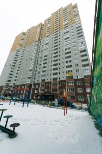 un gran edificio de apartamentos con nieve delante en Видовая квартира Yaroslavichi-2, en Vyshgorod