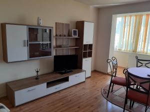 a living room with a television and a dining room table at Apartament Unirii Belvedere in Baia Mare