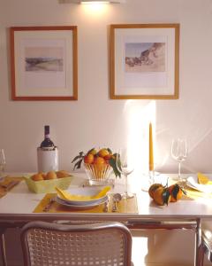 una mesa de comedor con una bandeja de fruta y copas de vino en Residence Hilda en Florence