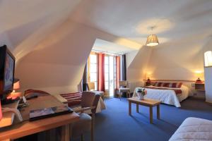 1 dormitorio con 1 cama y sala de estar en Logis Hôtel Restaurant & Spa les Remparts, en Salers