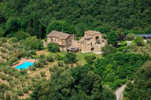 uma casa grande numa colina com piscina em Agriturismo Podere Cortilla em Volterra