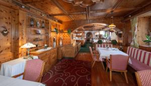 un ristorante con pareti e tavoli in legno e sedie di Hotel Metzgerwirt a Fieberbrunn