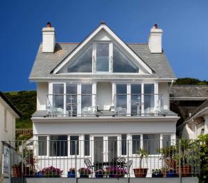 a white house with a balcony with chairs at Seaview in Looe
