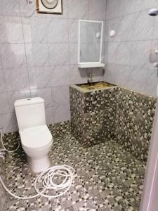 uma casa de banho com um WC branco e um lavatório. em Perhentian Chomel Chalet em Ilhas Perhentian