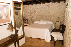 sypialnia z białym łóżkiem i lustrem w obiekcie Abuela Pastora w mieście El Torno