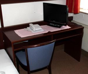 a desk with a laptop computer and a phone on it at Einfelder Hof garni in Neumünster