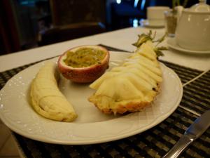 a white plate with a peeled banana and an orange at Hotel Ida Inés in Frontera