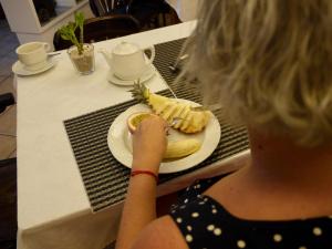 a woman sitting at a table with a plate of food at Hotel Ida Inés in Frontera