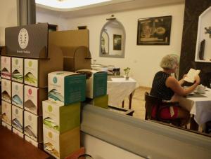a woman sitting at a table in a restaurant with boxes at Hotel Ida Inés in Frontera