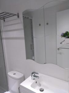 a white bathroom with a sink and a mirror at Apartamento Cigüeña in Logroño