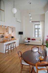 a kitchen and a living room with a table and chairs at Four Streets Athens - Luxury Suites Apartments in Athens in Athens
